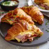 Two croissants filled with ham, eggs, and cheese.