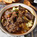 A hearty beef stew paired with bread on a table.