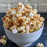 A bowl of gooey popcorn topped with marshmallows.