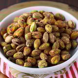 A bowl filled with almonds sitting on a table.