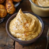 A bowl of smoky, creamy sauce with a spoon.