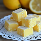 Lemon squares on a dish with a fresh lemon slice.
