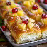 A tasty dessert topped with pineapple and cherries.
