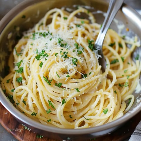 A close-up of pasta topped with fresh herbs and Parmesan.